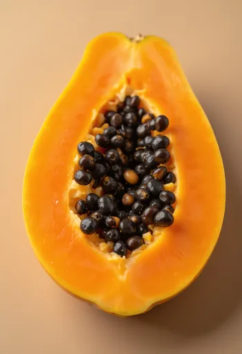 Свіжа нарізана папая на дерев'яній поверхні з чорним насінням