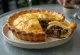 Seal flipper pie served in a rustic dish with golden puff pastry.